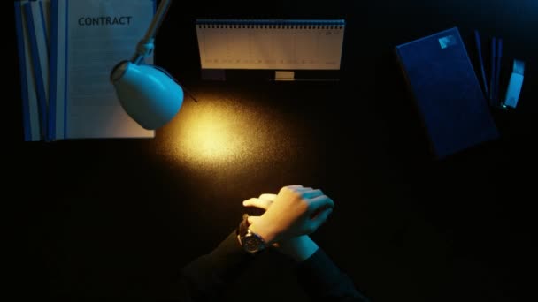 Um homem está sentado em uma mesa de escritório e usando um telefone . — Vídeo de Stock