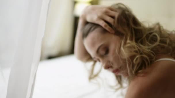 Жінка на ліжку дивиться в клітку з пристрастю і погладжує себе — стокове відео