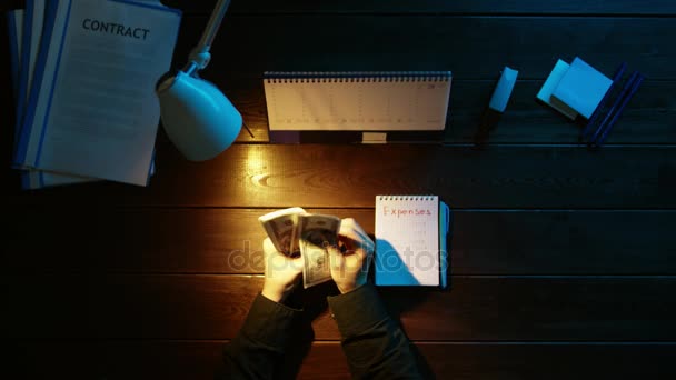 Egy férfi ül egy íróasztal, és a telefon használata. — Stock videók