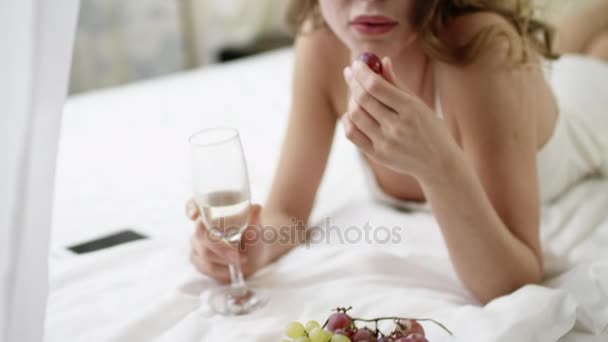 Woman eating grape and drinking champagne — Stock Video