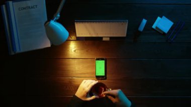 Bir adam bir ofis masa başında oturan ve bir telefon kullanma.