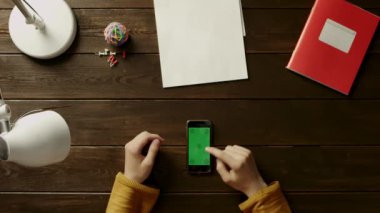 Klasör, lamba, top, office ve düğmeleri yanında telefon kullanarak masasındaki adam.