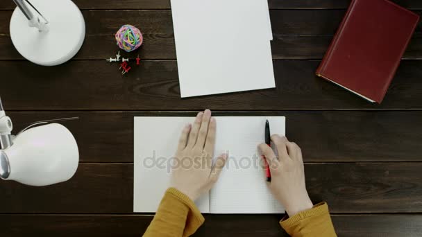 El hombre en el escritorio quiere escribir algo en el libro de texto, pero no se atreve, junto a la carpeta, lámpara, bola, oficina y botones . — Vídeo de stock