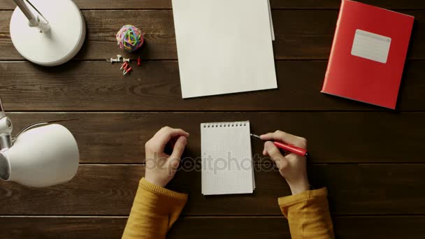 El hombre en el escritorio quiere escribir algo en el libro de texto, pero no se atreve, junto a la carpeta, lámpara, bola, oficina y botones . — Vídeo de stock