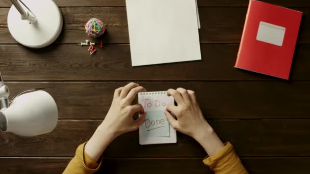 Orang di meja lem stiker di notebook, sebelah folder, lampu, bola, kantor dan tombol . — Stok Video