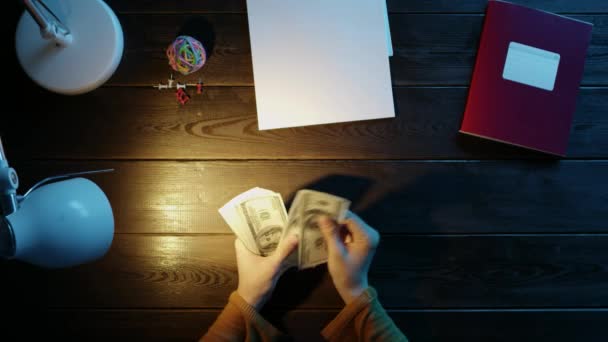 El hombre en el escritorio pegamento stikers en el cuaderno y contar el dinero, junto a la carpeta, lámpara, bola, oficina y botones . — Vídeos de Stock