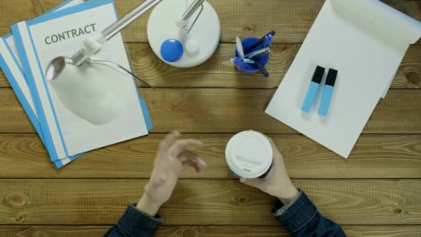 남자는 전화 및 음료 커피에 사무실 책상에 앉아 있다. 파란과 백색 음색에서 책상 사무 용품에. — 비디오