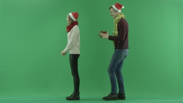 Junger Mann macht seiner Freundin ein schlechtes Weihnachtsgeschenk, Chroma-Schlüssel im Hintergrund — Stockvideo