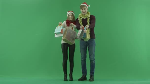 Junges Paar zeigt seine Einkaufstaschen in die Kamera, Chromaschlüssel im Hintergrund — Stockvideo