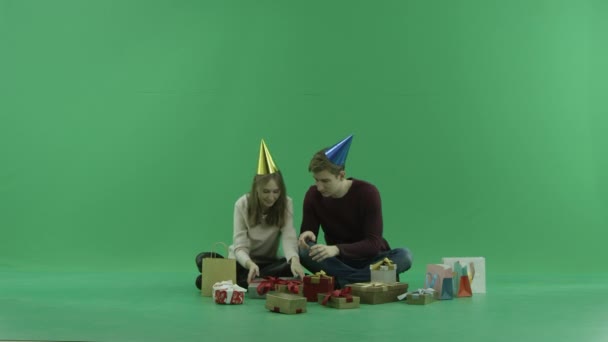 Ungt par öppnar en fin julklapp, Färgtransparens på bakgrund — Stockvideo