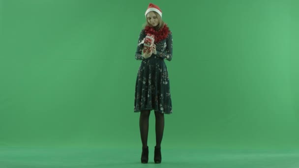 Young cute woman trying to understand what in her Christmas gift, chroma key on background — Stock Video