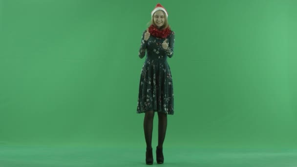 Young beautiful woman in Christmas hat shows two thumbs up, chroma key on background — Stock Video