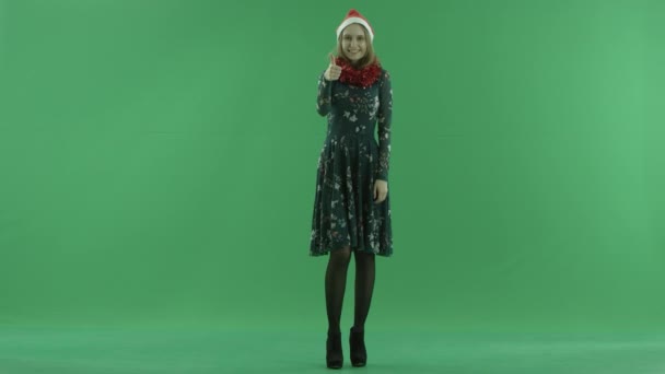 Young beautiful woman in Christmas hat shows thumb up, chroma key on background — Stock Video