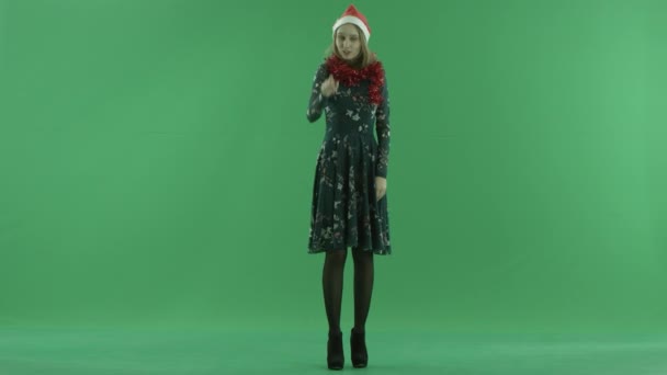 Young woman in Christmas hat points to the camera and invites everybody to come, chroma key on background — Stock Video