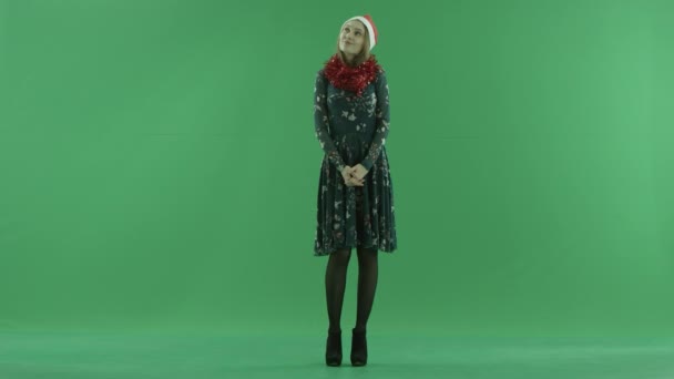 Atraktivní mladá šťastná žena v vánoční čepice před zeleným plátnem, chroma key na pozadí — Stock video