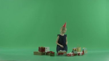 Sevimli küçük kız Noel hediyesi, chroma anahtar arka plan üzerinde seçmek çalışır