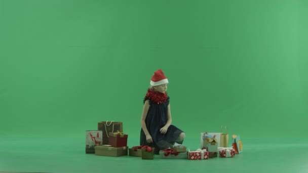 Bedårande liten flicka i Xmas hatt fick en fin julklapp, Färgtransparens på bakgrund — Stockvideo