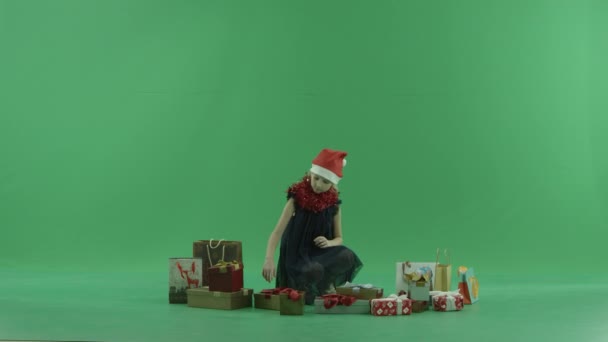 Sevimli küçük kız Xmas şapkalı Noel hediyesi, chroma anahtar arka plan üzerinde seçmek çalışır — Stok video