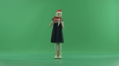 Sevimli küçük kız onun Xmas hediye kutusu, chroma anahtar arka plan üzerinde bakarak Noel şapkalı