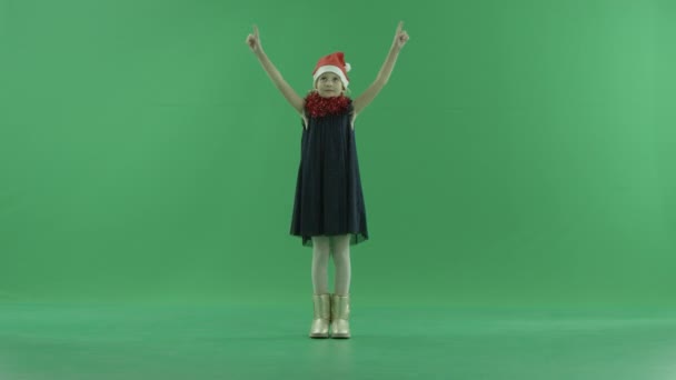 Roztomilá holčička v vánoční čepice nakreslí srdce ve vzduchu, klíčování chroma na pozadí — Stock video