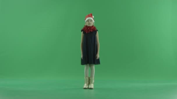 Petite fille mignonne dans le chapeau de Noël, clé chroma sur fond — Video