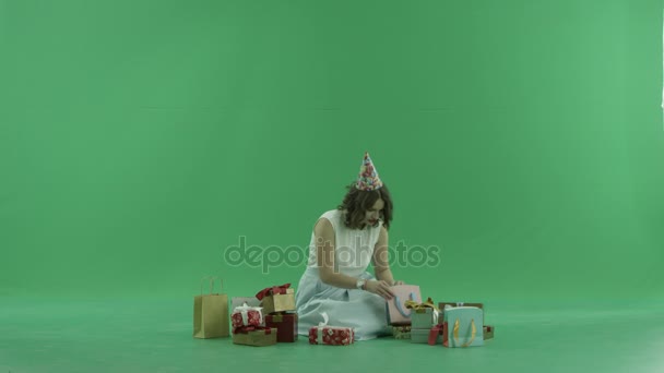 Ung kvinna tittar på hennes jul presenterar och väskor, Färgtransparens på bakgrund — Stockvideo