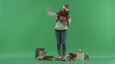 Çekici genç kadın Noel şapkalı selfie Noel hediyesi, chroma anahtar arka plan üzerinde ile alır