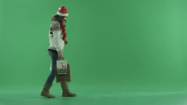 Attrayant jeune femme marche avec des sacs à provisions, clé chroma sur fond — Video