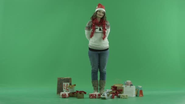 Привлекательная молодая женщина в рождественской шляпе с подарком на Рождество, хрома ключ на заднем плане — стоковое видео