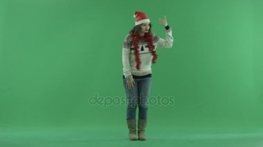 Güzel genç kadın Noel şapkalı biri el hareketi ile chroma anahtar arka plan üzerine gelmek için davet ediyor