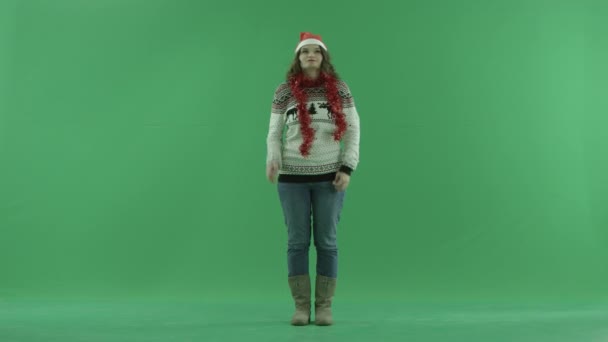 Bir şey, chroma anahtar arka plan üzerinde Noel şapka çekici genç kadın düşünüyor — Stok video