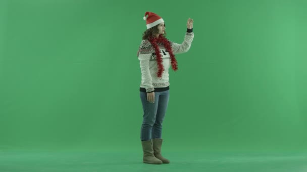 Ernsthafte junge Frau in Weihnachtsmütze mit virtuellem Bildschirm, Chroma-Taste auf dem Hintergrund — Stockvideo