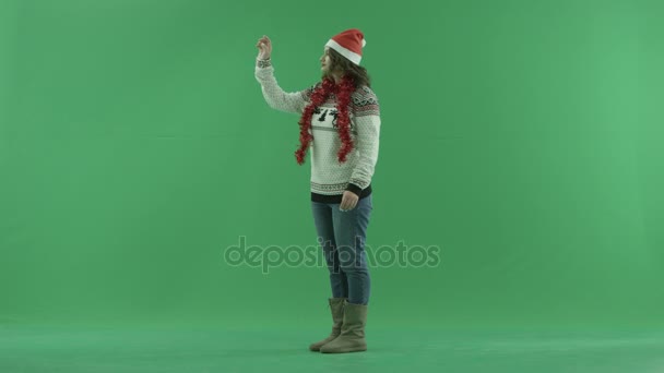 Encantadora joven en sombrero de Navidad con tecnología de pantalla de realidad aumentada, croma clave en el fondo — Vídeo de stock