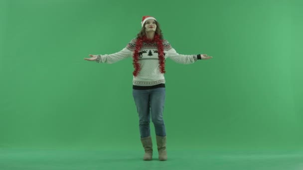 Красивая молодая женщина в рождественской шляпе наслаждается снегопадом, хрома ключ на заднем плане — стоковое видео
