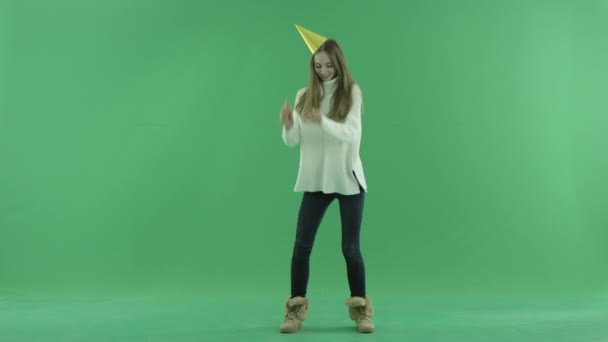 Attractive happy young woman dances and blows in whistle, chroma key on background — Stock Video