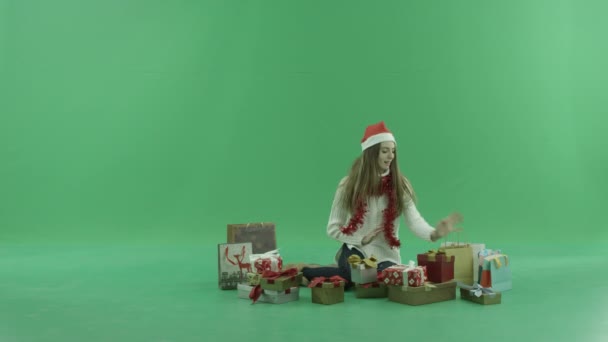 Привлекательная молодая женщина в рождественской шляпе получает очень хороший рождественский подарок, который делает ее счастливой, хрома ключ на заднем плане — стоковое видео