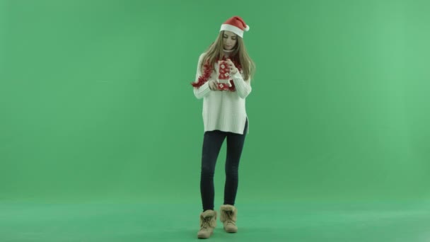 Noel şapka genç kadın çekici ne onun Xmas hediyesi, chroma anahtar arka plan üzerinde yatıyor bulmaya çalışır — Stok video