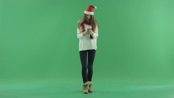 Boldog, fiatal szőke nő karácsonyi kalap smartphone, a háttér chroma-kulcs — Stock videók