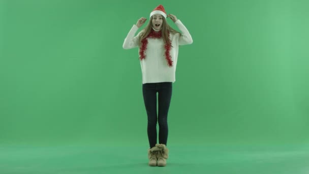 Bedårande ung kvinna i jul hatt ser överväldigad och förvånad, Färgtransparens på bakgrund — Stockvideo
