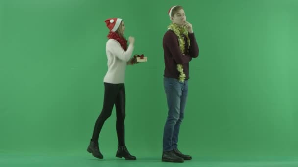 Mladá žena dává její přítel špatný vánoční dárek s chroma klíč na pozadí — Stock video