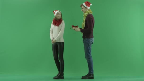 Jonge man geeft zijn vriendin een goede gift van Kerstmis, Chromakey op achtergrond — Stockvideo