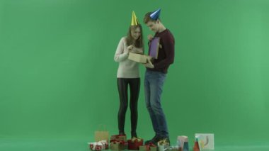 Genç bir çift boş Noel hediyesi, chroma anahtar arka plan üzerinde açar