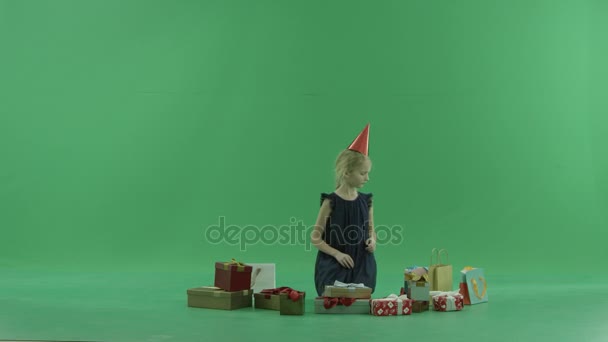 Adorable niña intenta elegir regalo de Navidad, croma clave en el fondo — Vídeo de stock