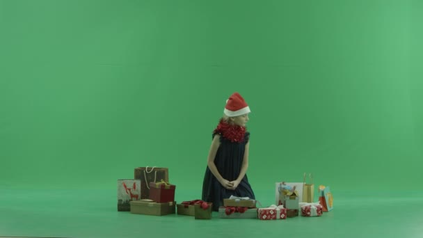 Schattig meisje in KERSTMUTS opent lege kerstcadeau, Chromakey op achtergrond — Stockvideo