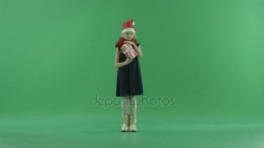 Sevimli küçük kız Noel şapkalı ne Xmas hediye kutusunda, chroma anahtar arka plan üzerinde yatıyor anlamaya çalışır