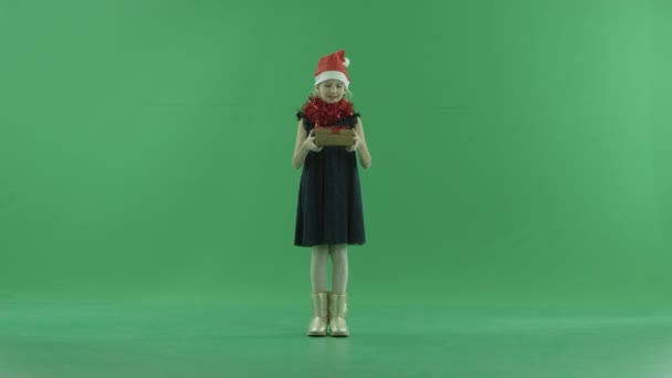 Sevimli küçük kız Noel şapkalı bir boş Xmas hediyesi, chroma anahtar arka plan üzerinde var — Stok video