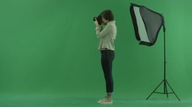 Çekici bir genç kadın, yeşil ekranın sol tarafında fotoğraf ve ayakta bir modelinin düzeltir