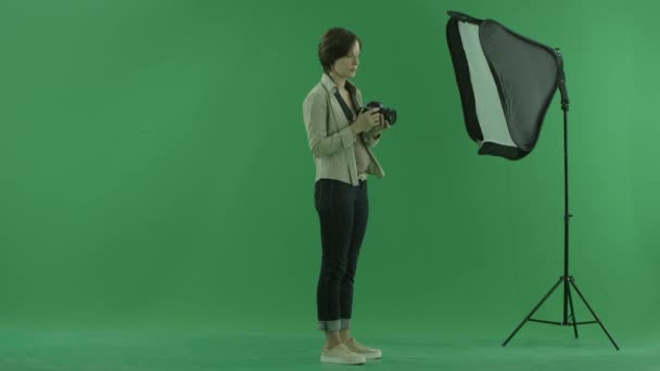 Uma jovem está tentando usar a câmera para o lado direito na tela verde — Vídeo de Stock