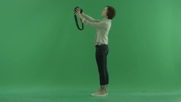 Una joven está tomando fotos de sí misma en el lado izquierdo de la pantalla verde — Vídeos de Stock