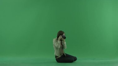 Genç kadın oturup fotoğraf yeşil ekranda sağ tarafta alıyor